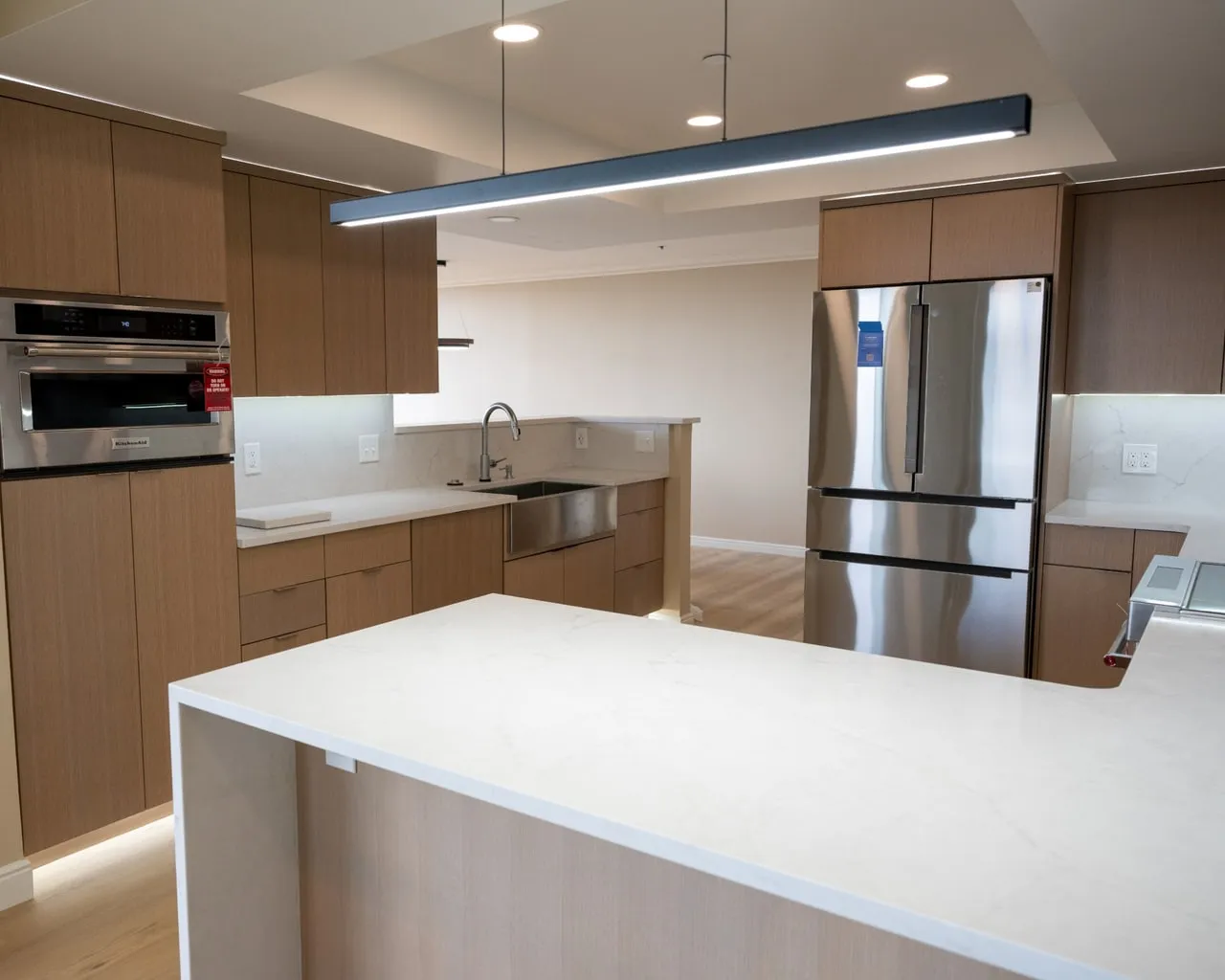 Finished kitchen remodel with a stainless farmhouse sink, pull-down faucet and stone counters