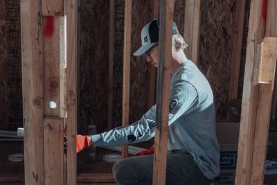 Black Forest Plumbing plumber running rough-in plumbing through wood framing on a new home